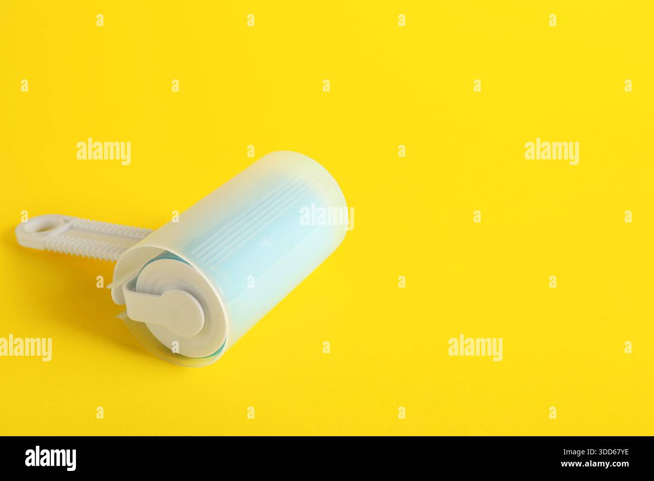 Lint roller on yellow background Stock Photo