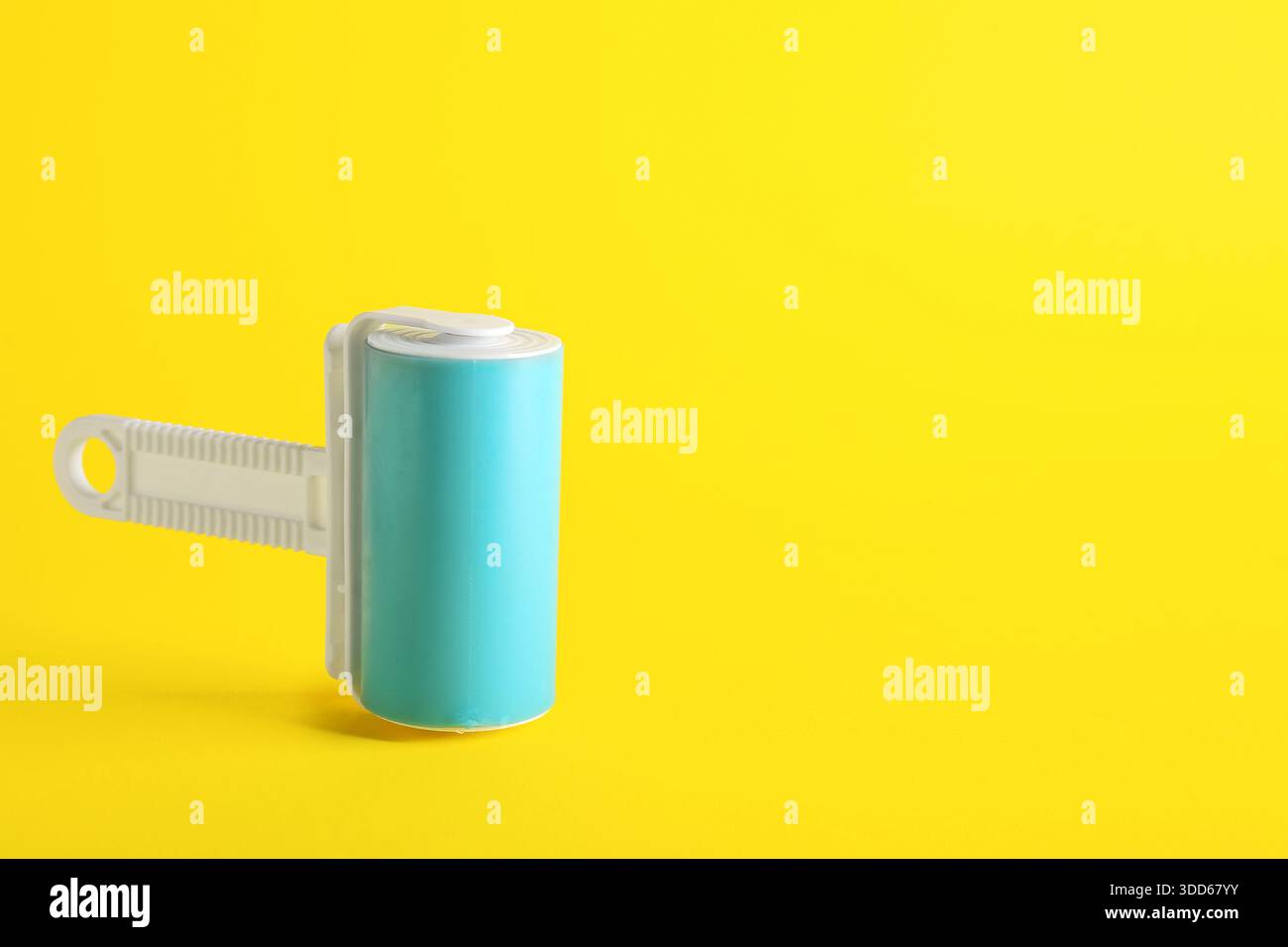 Lint roller on yellow background Stock Photo