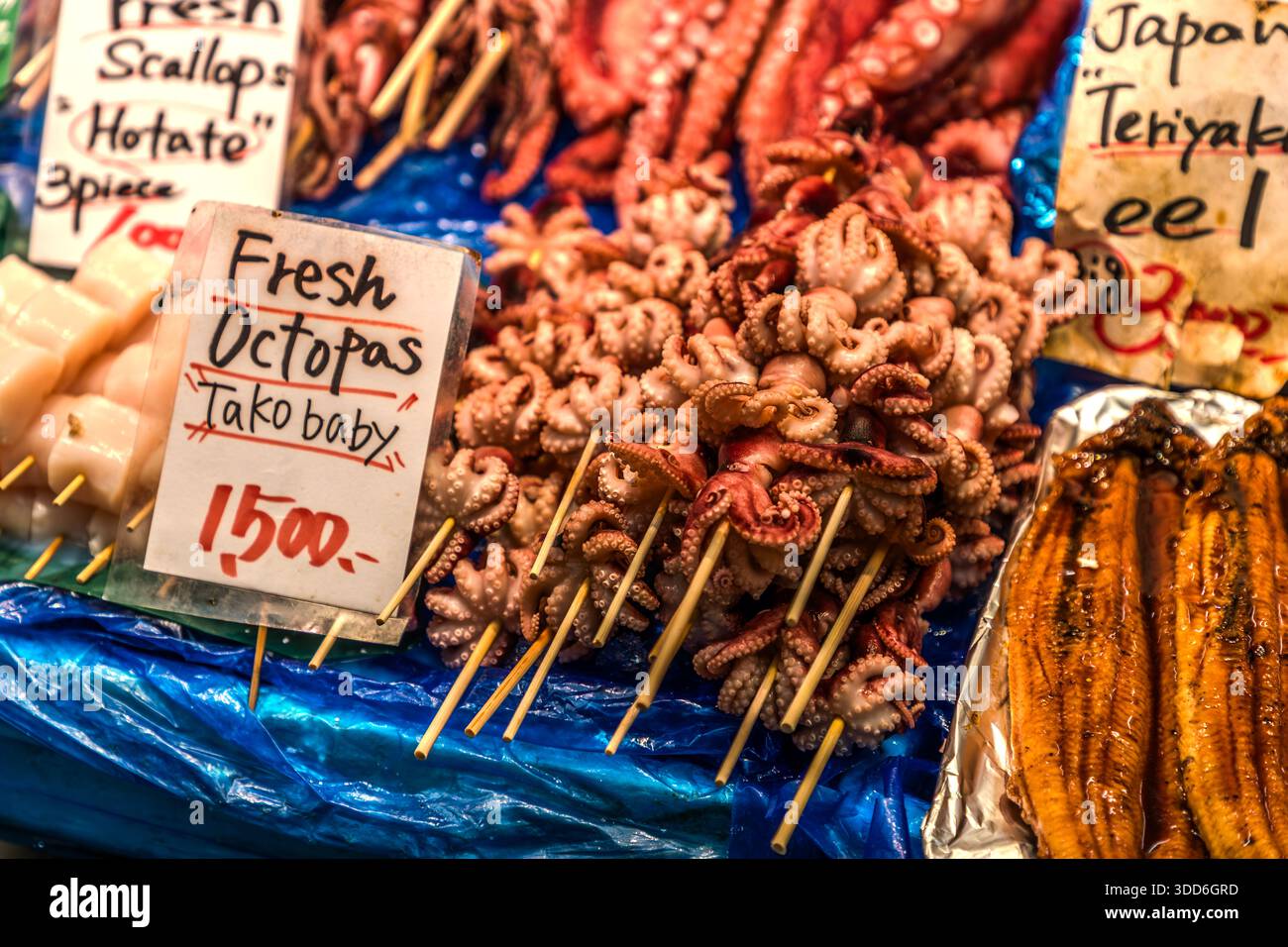 Tako-Baby, fresh octopus at Kurromon Market in Osaka. Fresh baby octopuses are offered for sale on skewers. Osaka, Osaka Prefecture, Japan Stock Photo