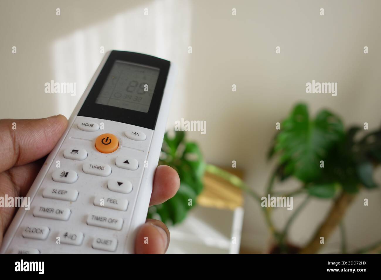 Hand holds a remote control for air conditioning unit Stock Photo