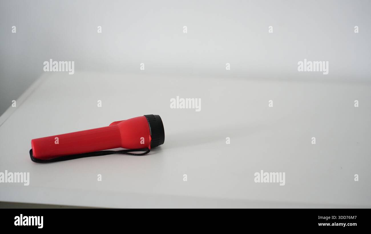 Battery powered flashlight on a white background. Copy space. Stock Photo
