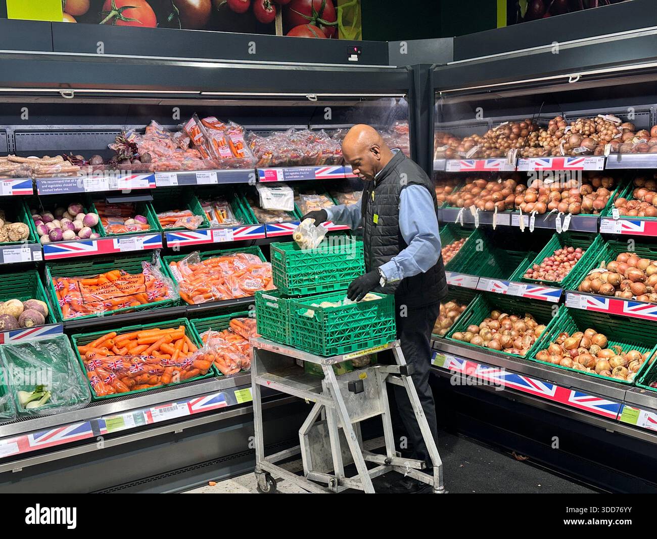 London, UK.27th December 2025. A staff member arranges commodities at a  supermarket as the New