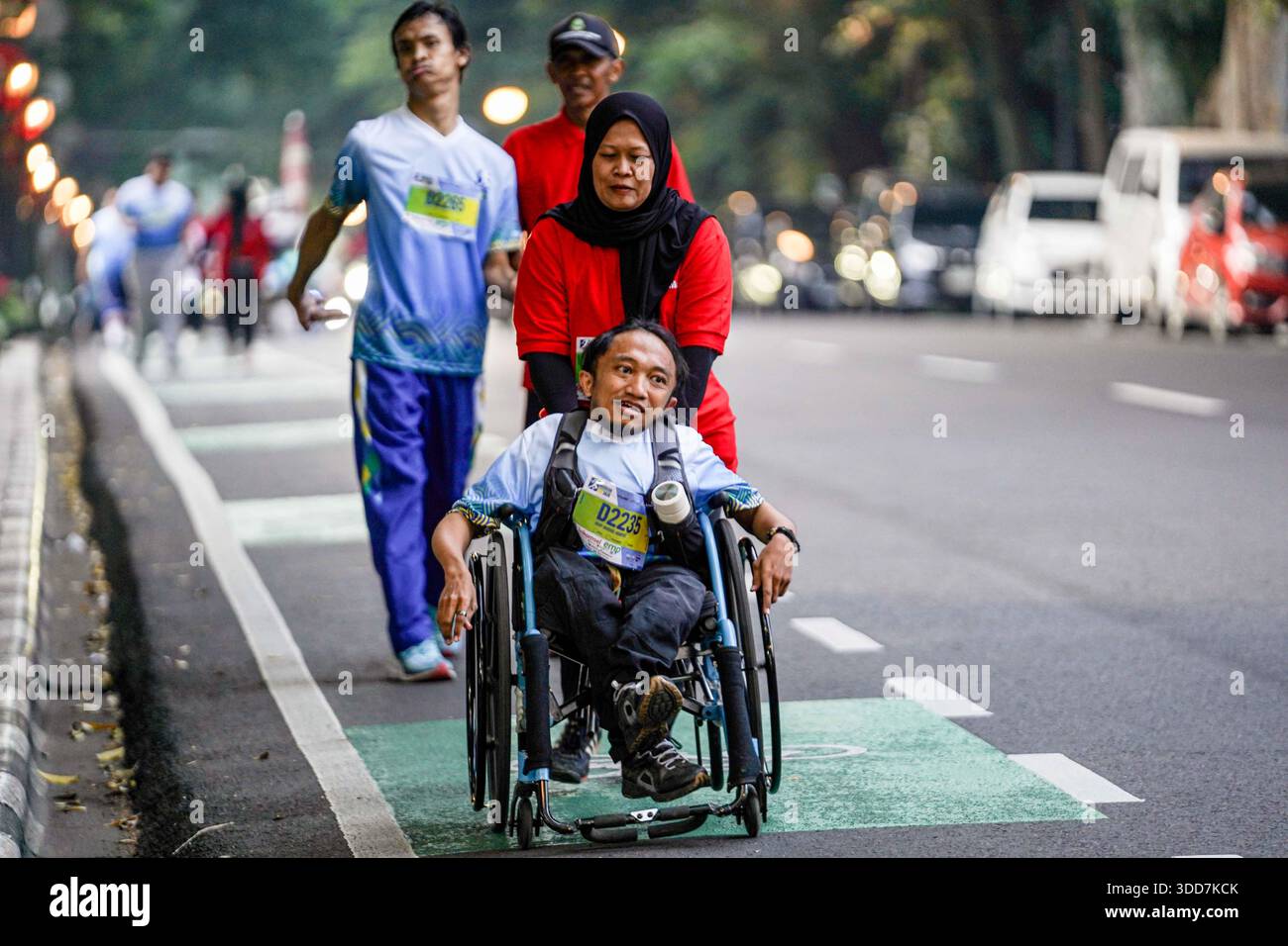 Disabled runners using wheelchairs cross Jalan Wastukencana, Bandung ...