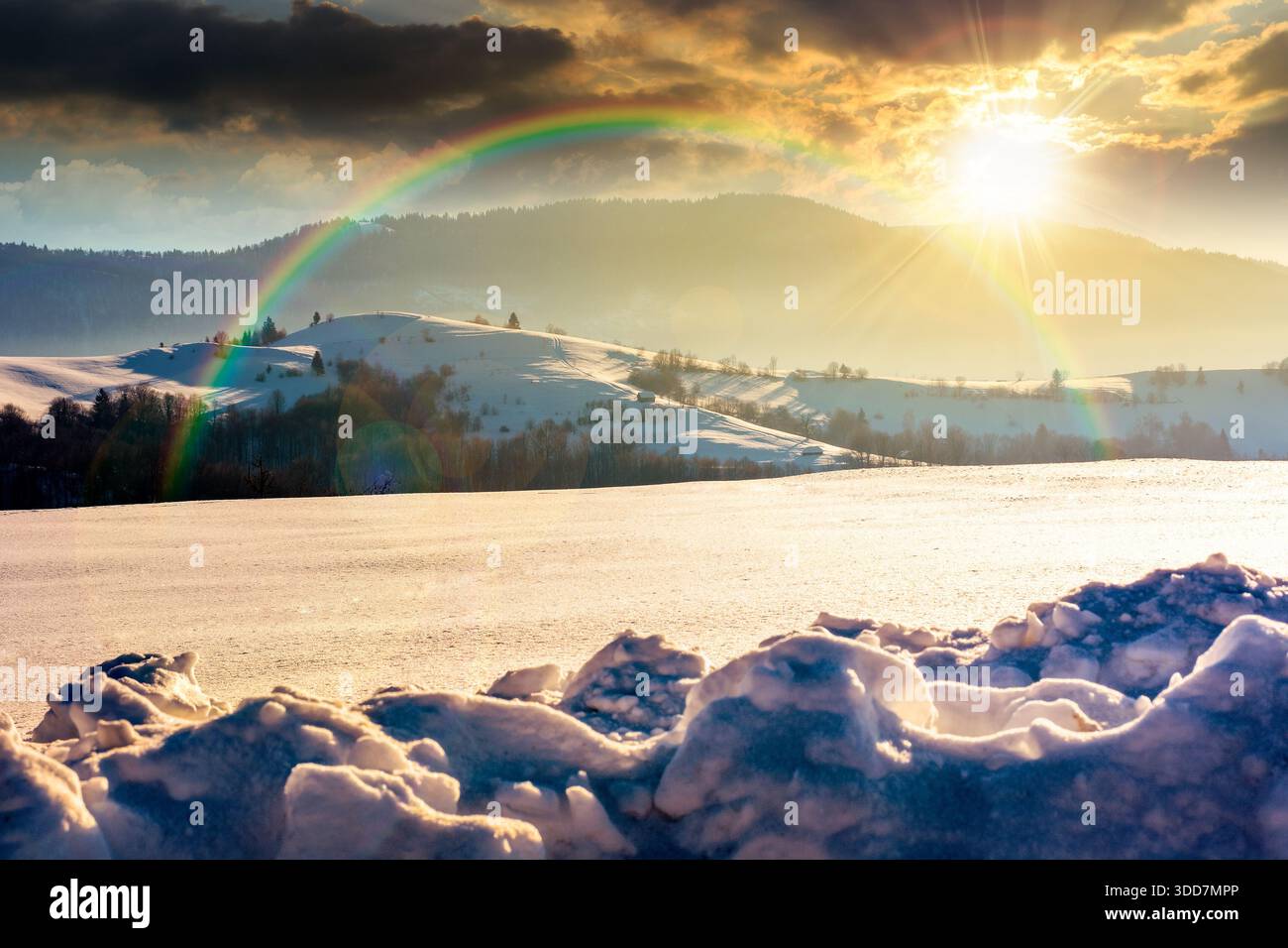 beautiful winter landscape with snow covered rolling hills under blue sky at sunset. majestic mountains in evening light. frosty countryside scenery. Stock Photo
