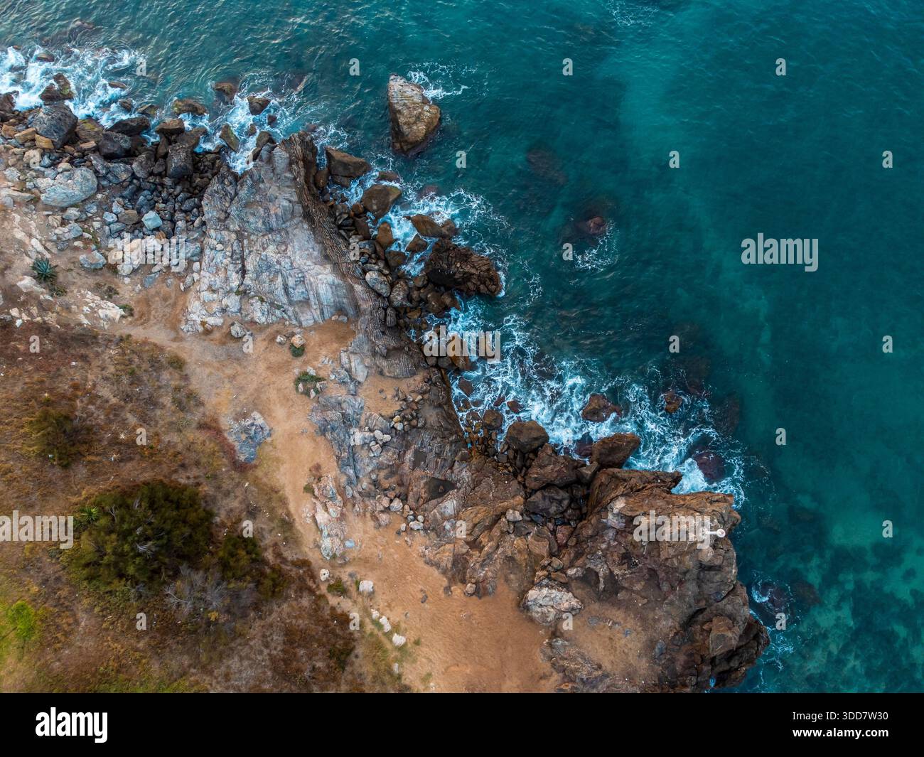 Aerial Top Down View Of Rocky Coastline And Clear Turquoise Sea Water, Mediterranean Coast, Waves Crashing On Rocks Stock Photo