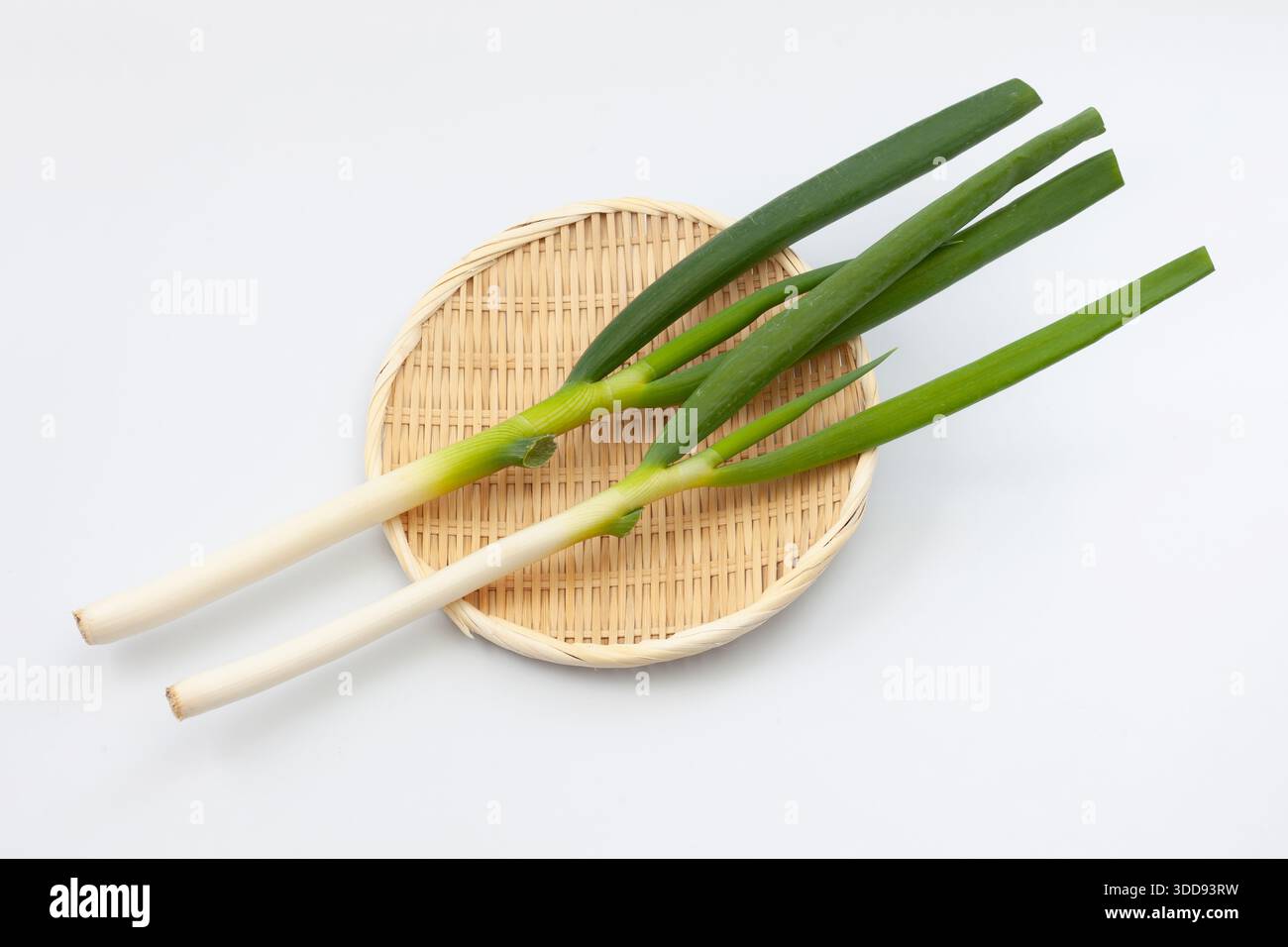 green onion on bamboo strainer on white background Stock Photo