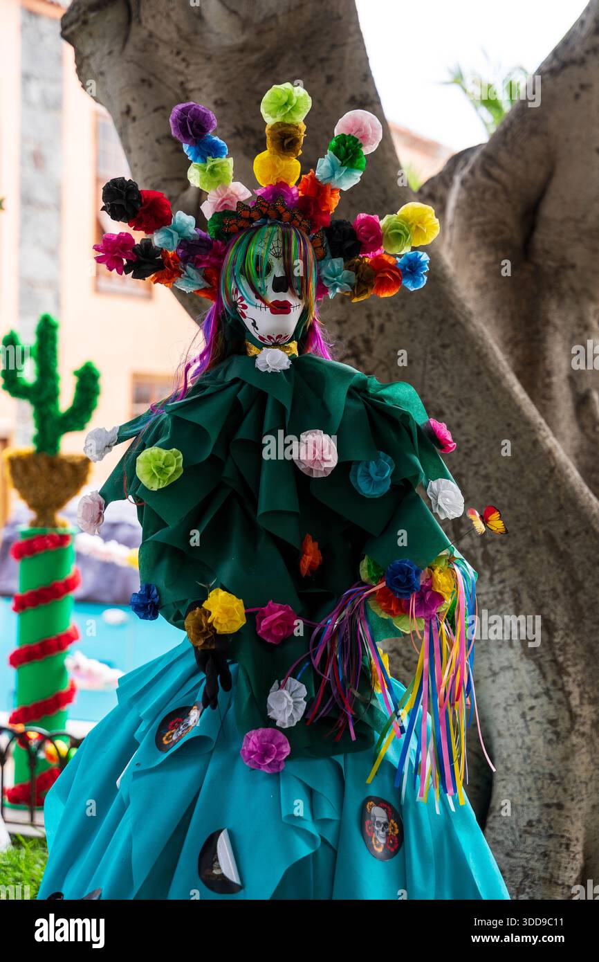 Festival mannequin in green dress with painted skull head and colorful paper flower crown during Fiesta de la Muerte, Canary Islands. Stock Photo