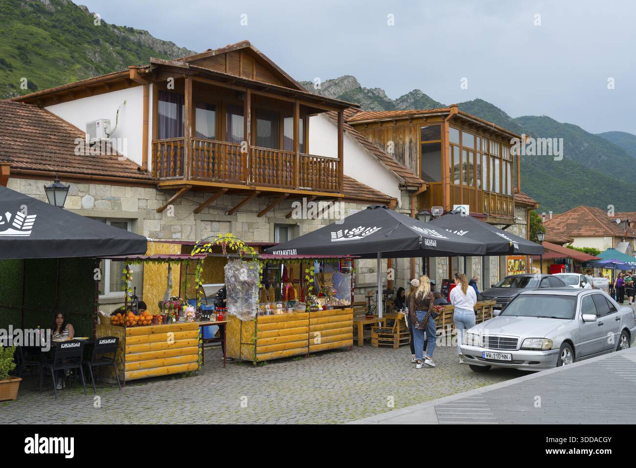 Cosy marketplace with cafes and shops framed by mountains under a cloudy sky, houses on Mtskheta Square, Mtskheta, Mtskheta, Mtskheta, Mtskheta-Mtiane Stock Photo