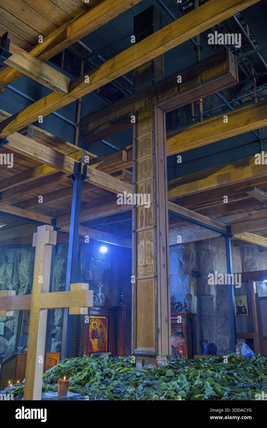 Interior with wooden cross, wooden beams and plants under artificial ...