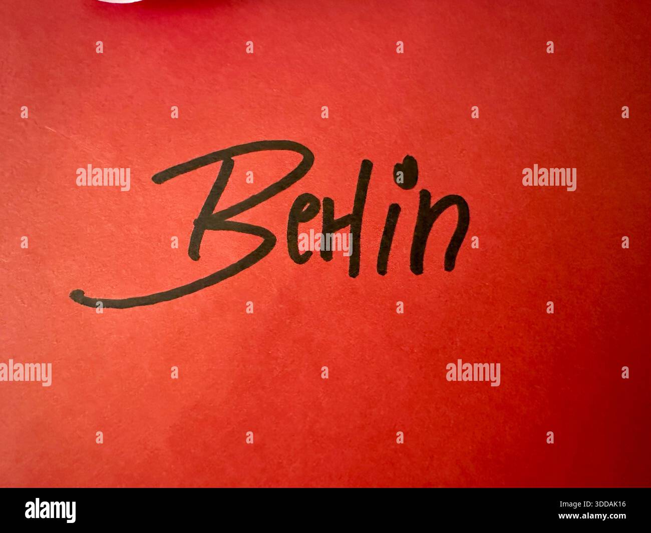 The word Berlin written with a black marker on a red paper - Smartphone Captured Stock Image
