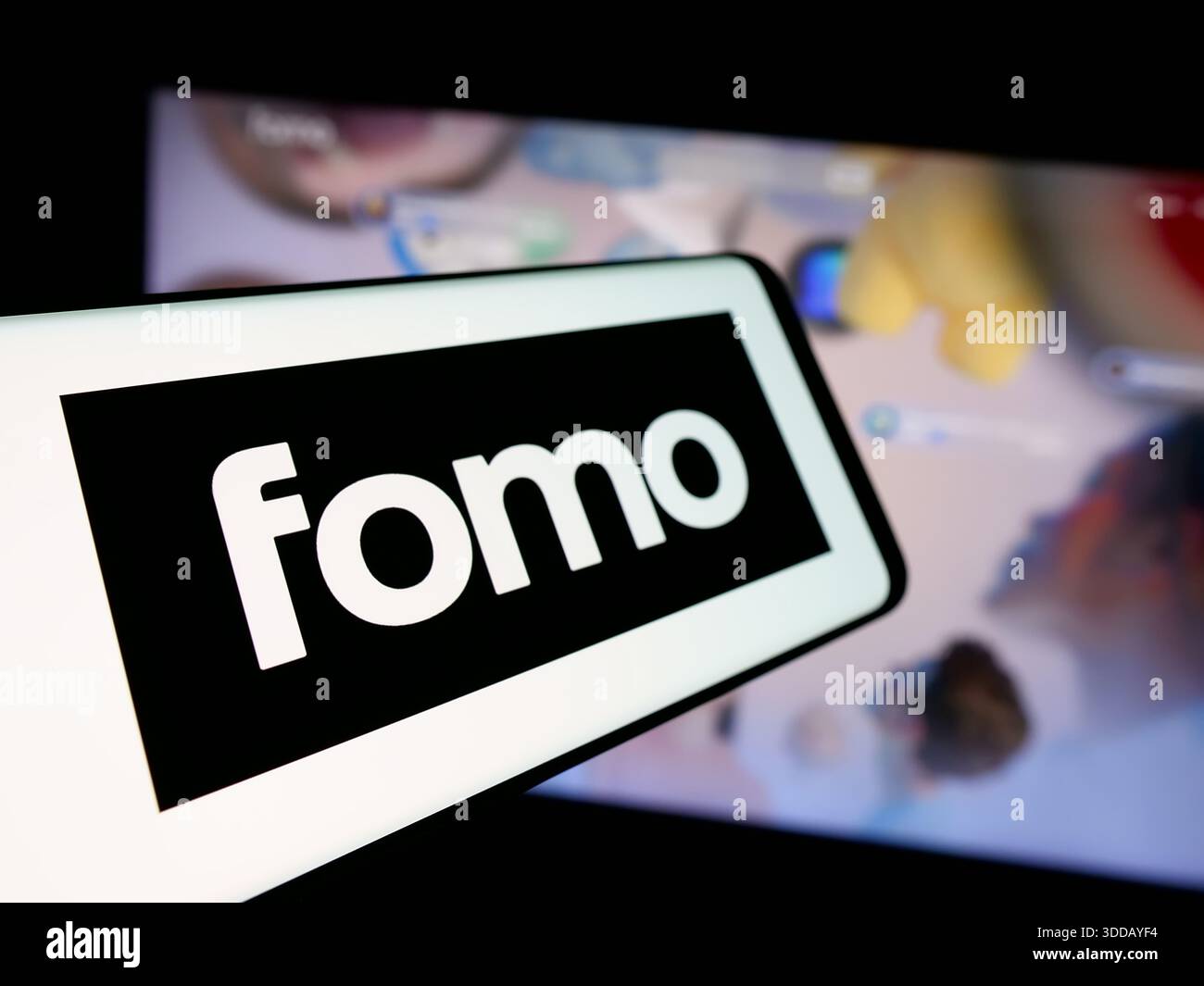 In this photo illustration, a smartphone with the logo of crypto company  FOMO Labs Inc. (fomo.family) is seen on screen in front of website. (Photo  by Timon Schneider / SOPA Images/Sipa USA) ***