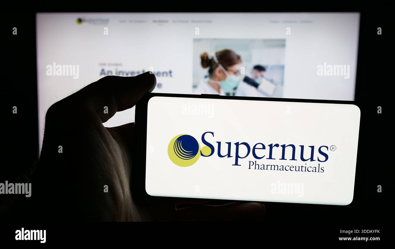 Supernus In this photo illustration, a person is holding a mobile phone with the ...