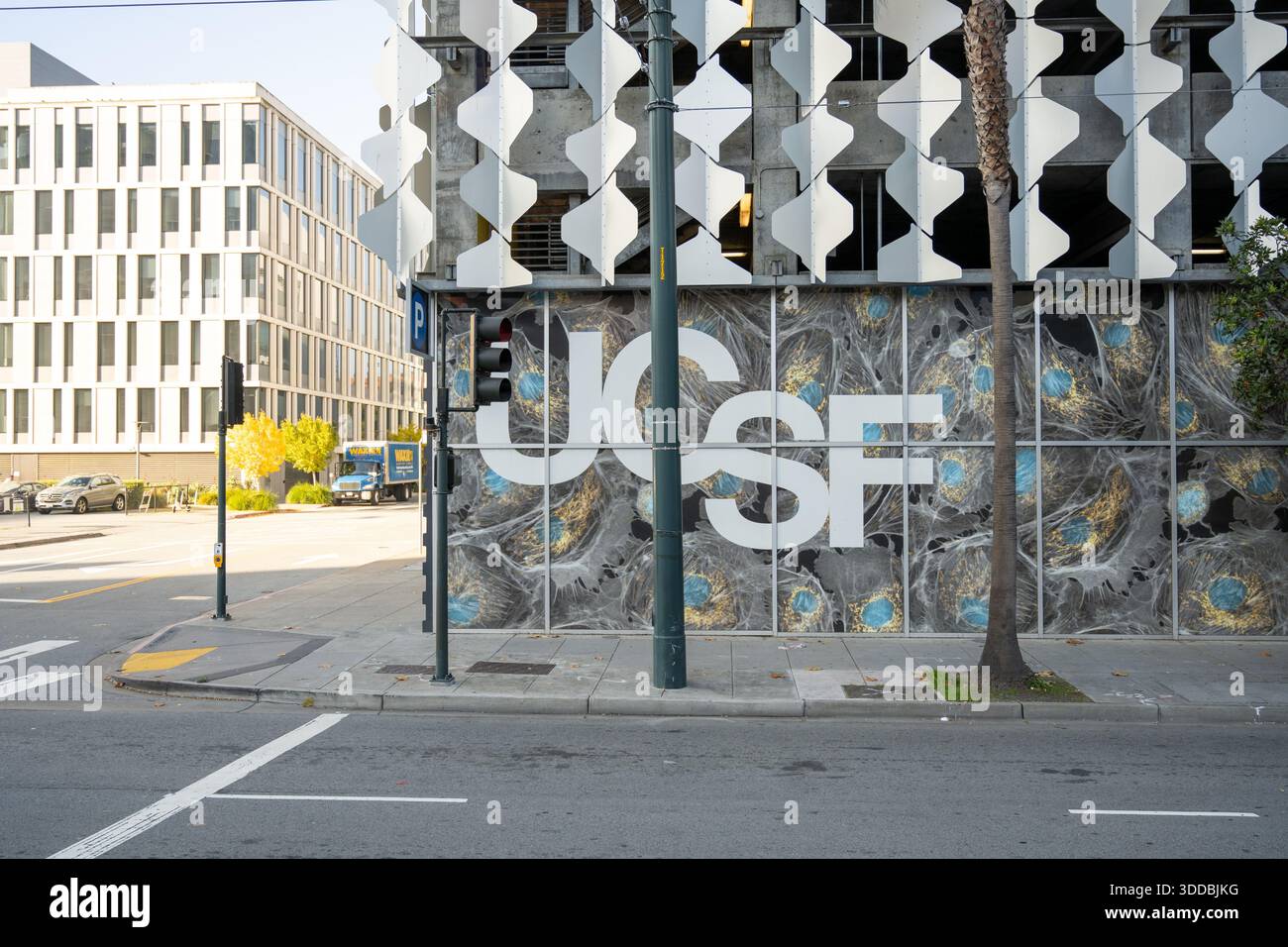 Street view of UCSF building facade with large logo and abstract ...