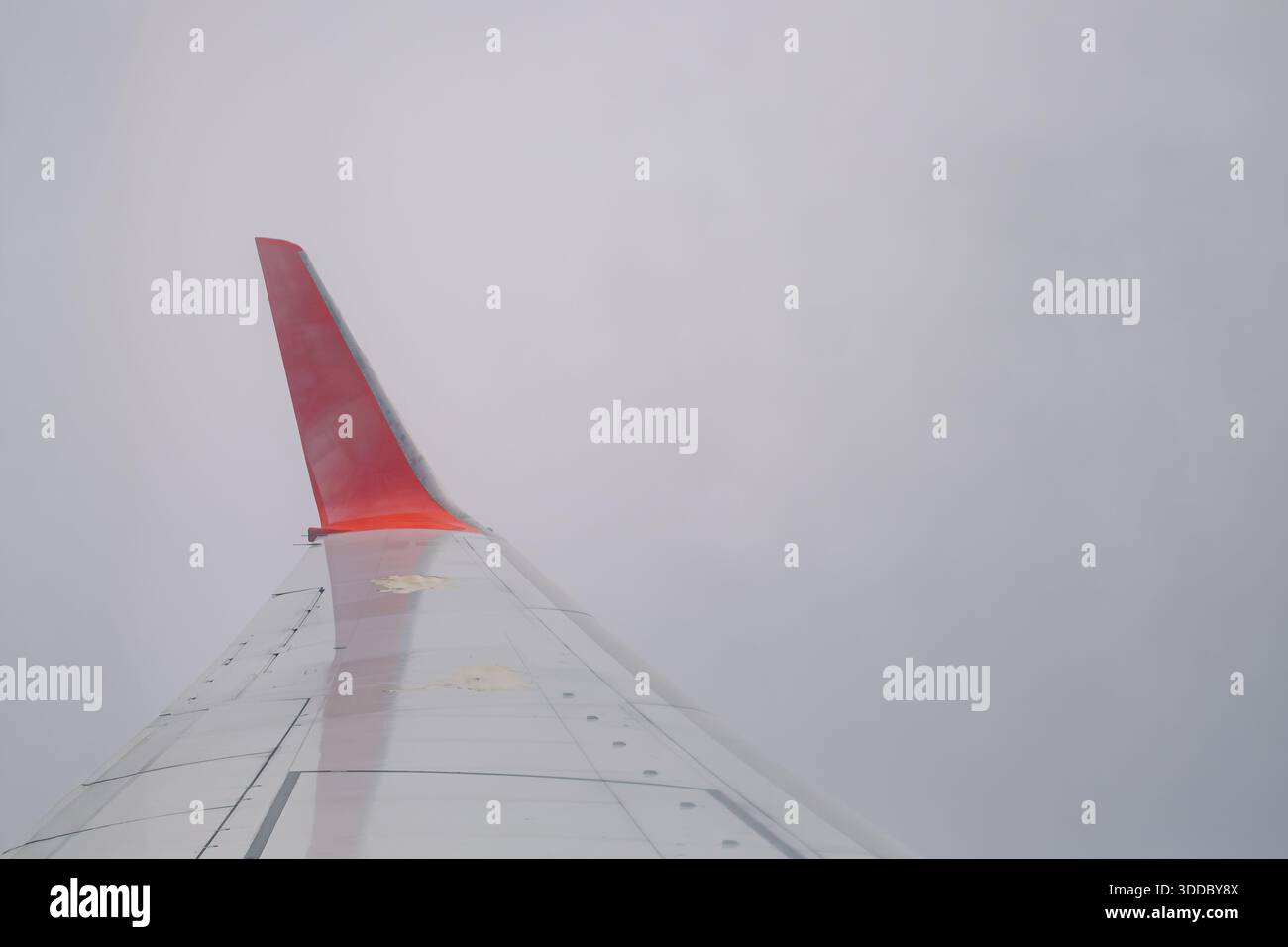 Close-up view of an airplane winglet with a red tip and white/silver ...