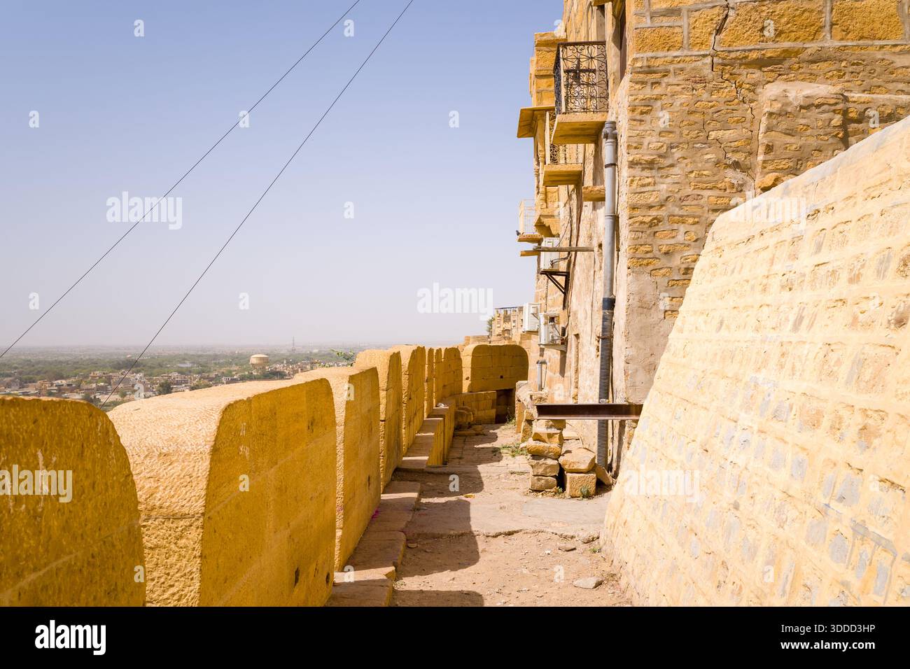 Golden sandstone walkway runs beside the ancient ramparts of Jaisalmer ...