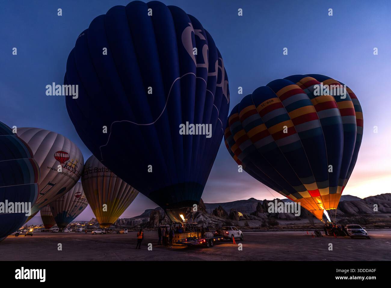 Hot air balloons are inflated before sunrise in Göreme, Central Anatolia Region, Turkey Stock Photo