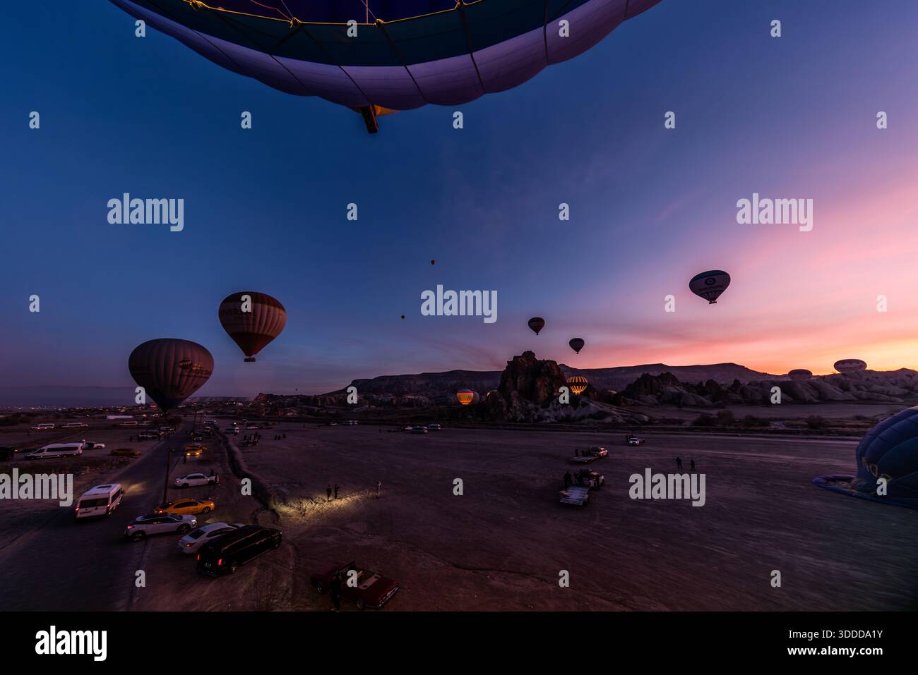 Hot air balloons take off near Göreme in Cappadocia before sunrise. Central Anatolia Region, Turkey Stock Photo