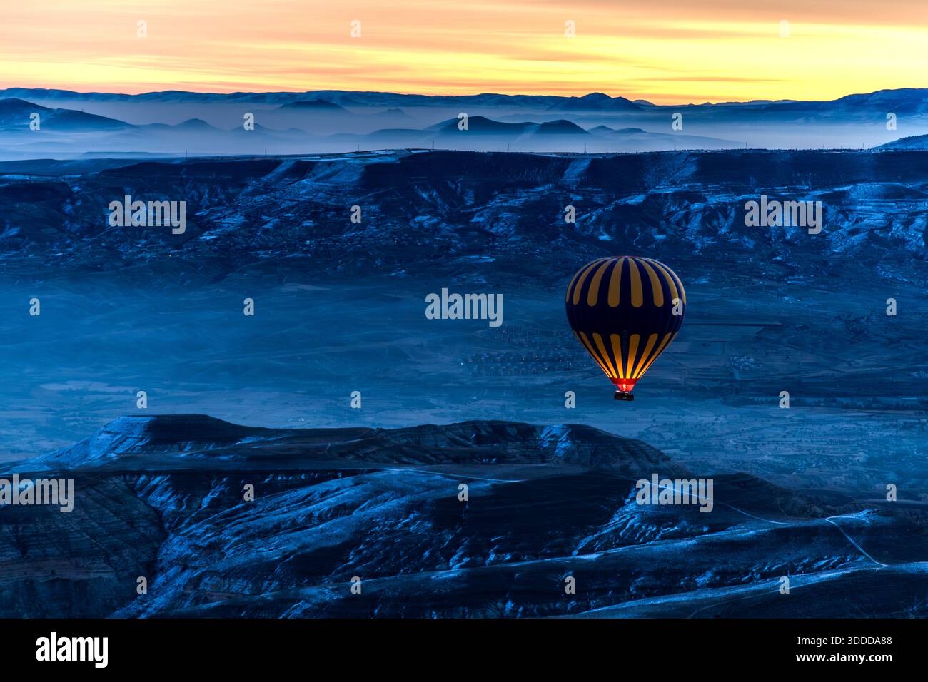 Hot air balloons rise above the rock formations of Göreme at sunrise, Central Anatolia Region, Turkey Stock Photo