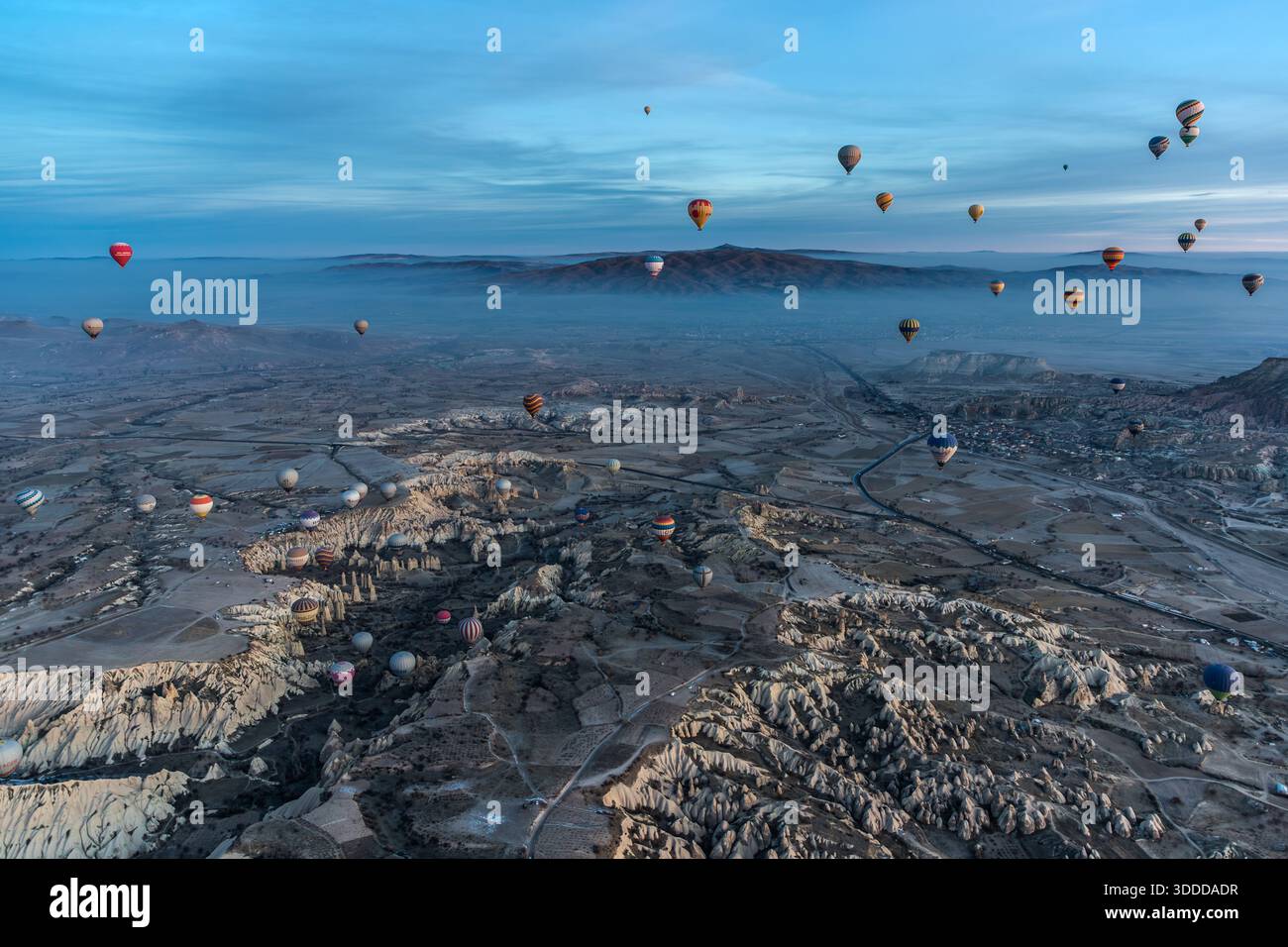 Many hot air balloons float above the snow-covered tuff landscape of Göreme. Central Anatolia Region, Turkey Stock Photo