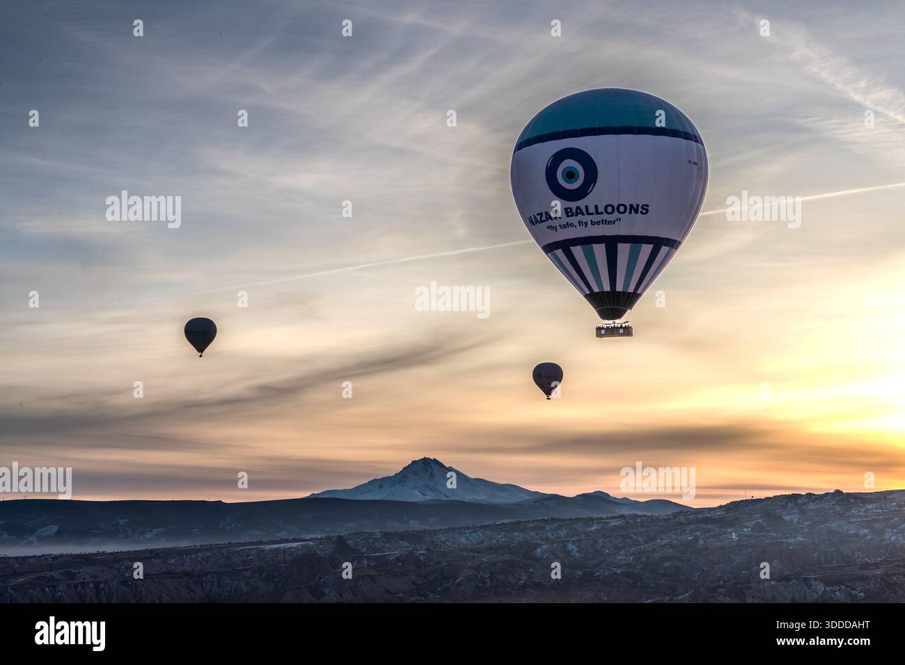 Hot air balloons from Nazar Balloons rise above Göreme at sunrise, Central Anatolia Region, Turkey Stock Photo