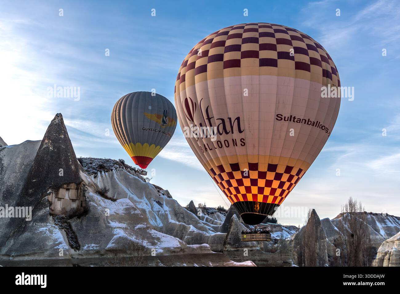 Hot air balloons between the rock formations of Göreme. Some fairy chimneys in the tuff landscape are inhabited. Sultan Balloons and Güvercin Balloons of Central Anatolia Region, Turkey Stock Photo