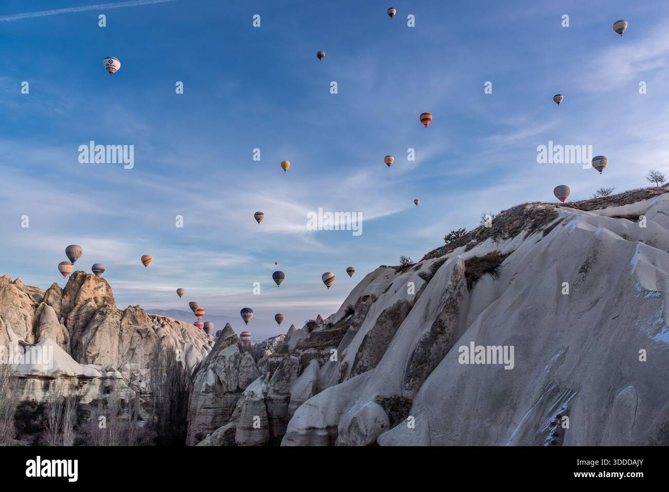 Hot air balloons rise above the rock formations of Göreme, Central Anatolia Region, Turkey. Tuff stone landscape and fairy chimneys Stock Photo