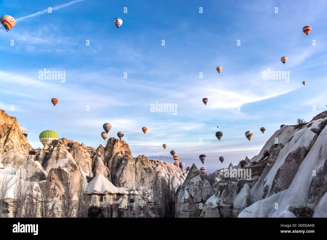 Hot air balloons rise above the rock formations of Göreme, Central Anatolia Region, Turkey. Tuff stone landscape and fairy chimneys Stock Photo