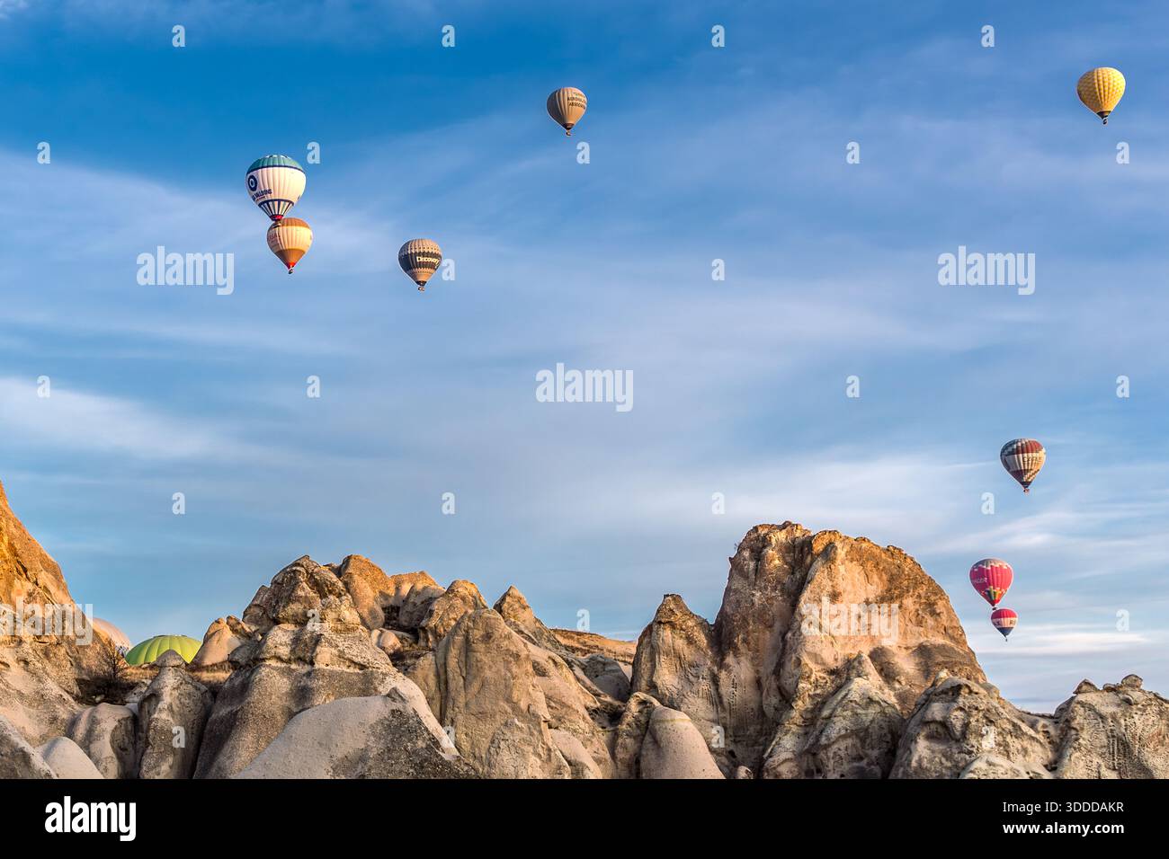 Hot air balloons rise above the rock formations of Göreme, Central Anatolia Region, Turkey. Tuff stone landscape and fairy chimneys Stock Photo