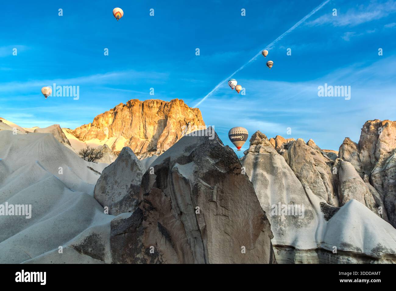 Hot air balloons rise above the rock formations of Göreme, Central Anatolia Region, Turkey. Tuff stone landscape and fairy chimneys Stock Photo