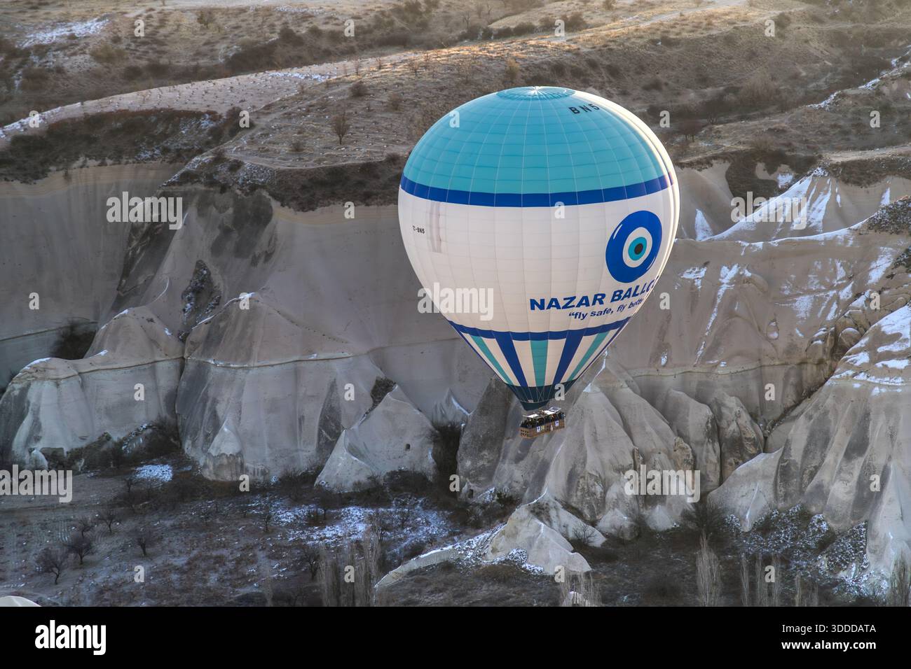Hot air balloon from Nazar Baloon glides over the rock formations in Göreme, Central Anatolia Region, Turkey Stock Photo