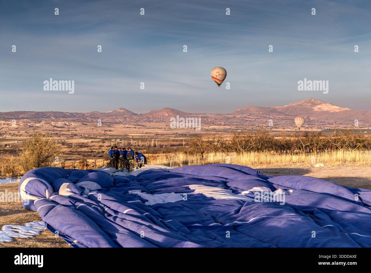 Balloon team folds up hot air balloon, Central Anatolia Region, Turkey Stock Photo