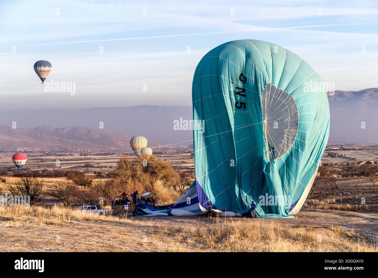 Hot air balloons land near Göreme, Central Anatolia Region, Turkey Stock Photo