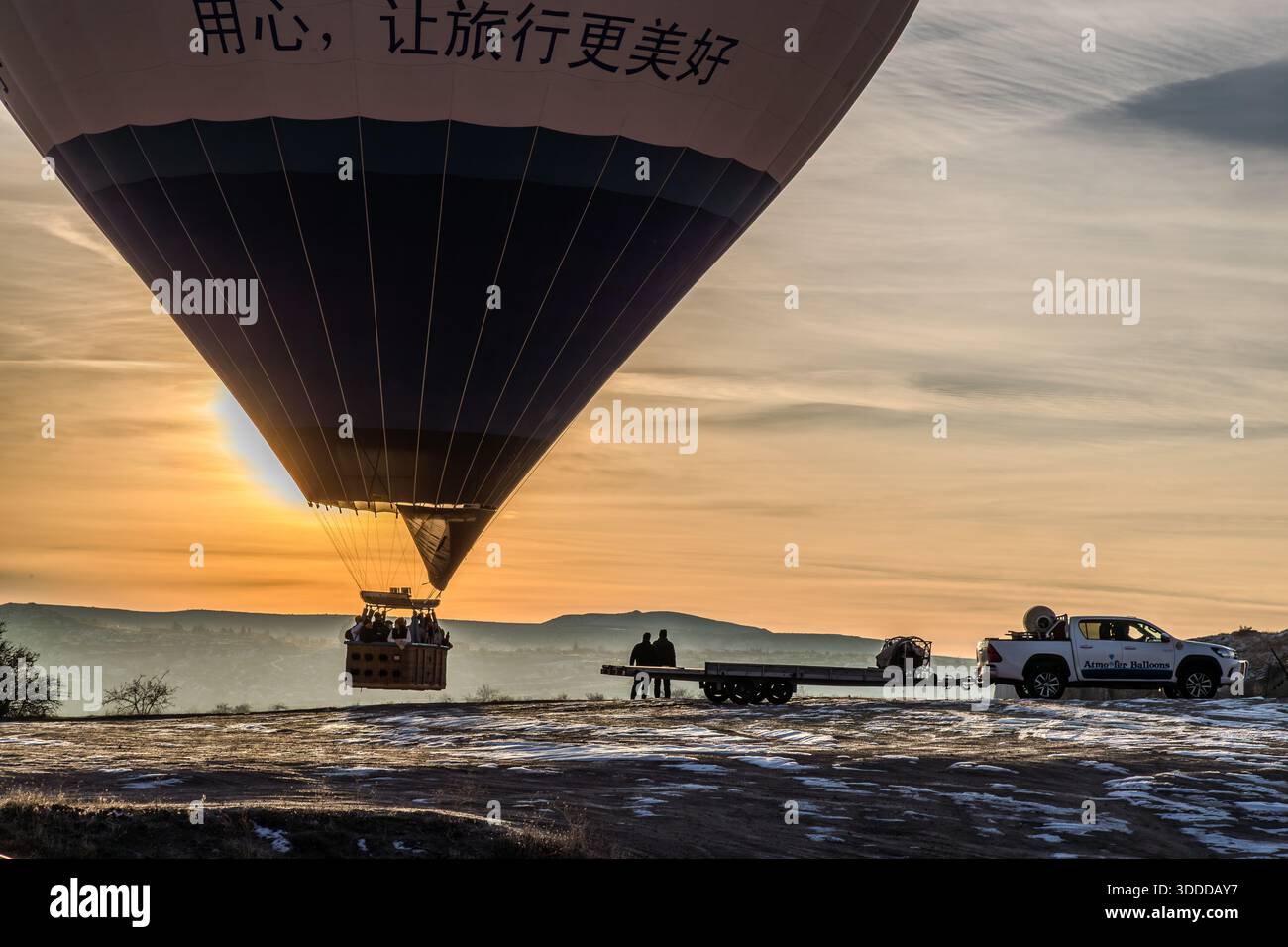 Hot air balloon with passengers lands at sunrise in Göreme, Central Anatolia Region, Turkey Stock Photo