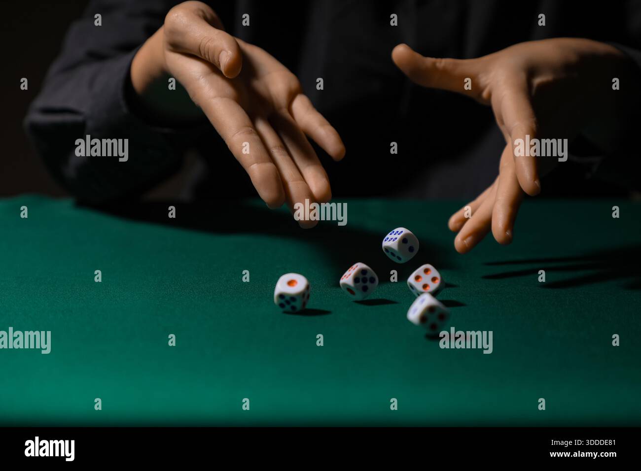 Man throwing white game dices on green table, closeup Stock Photo