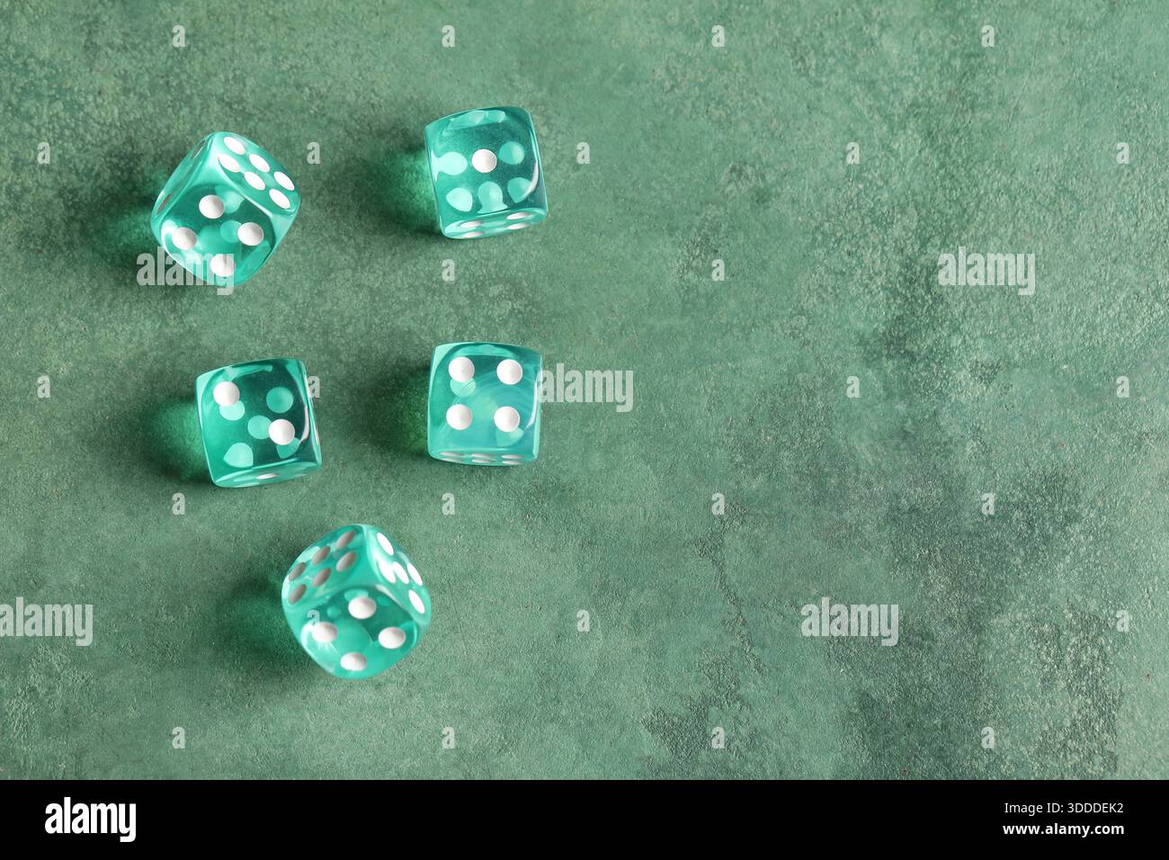 Turquoise game dices on green background Stock Photo