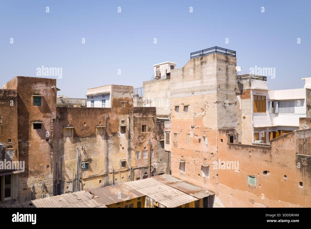 A cluster of old buildings with textured, faded walls and exposed ...
