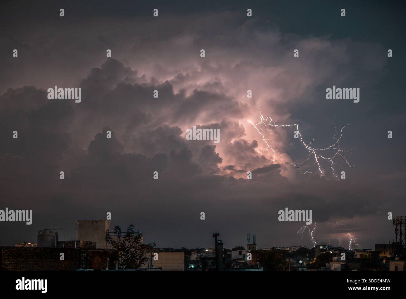 Lightning strikes during a severe thunderstorm over an urban city ...