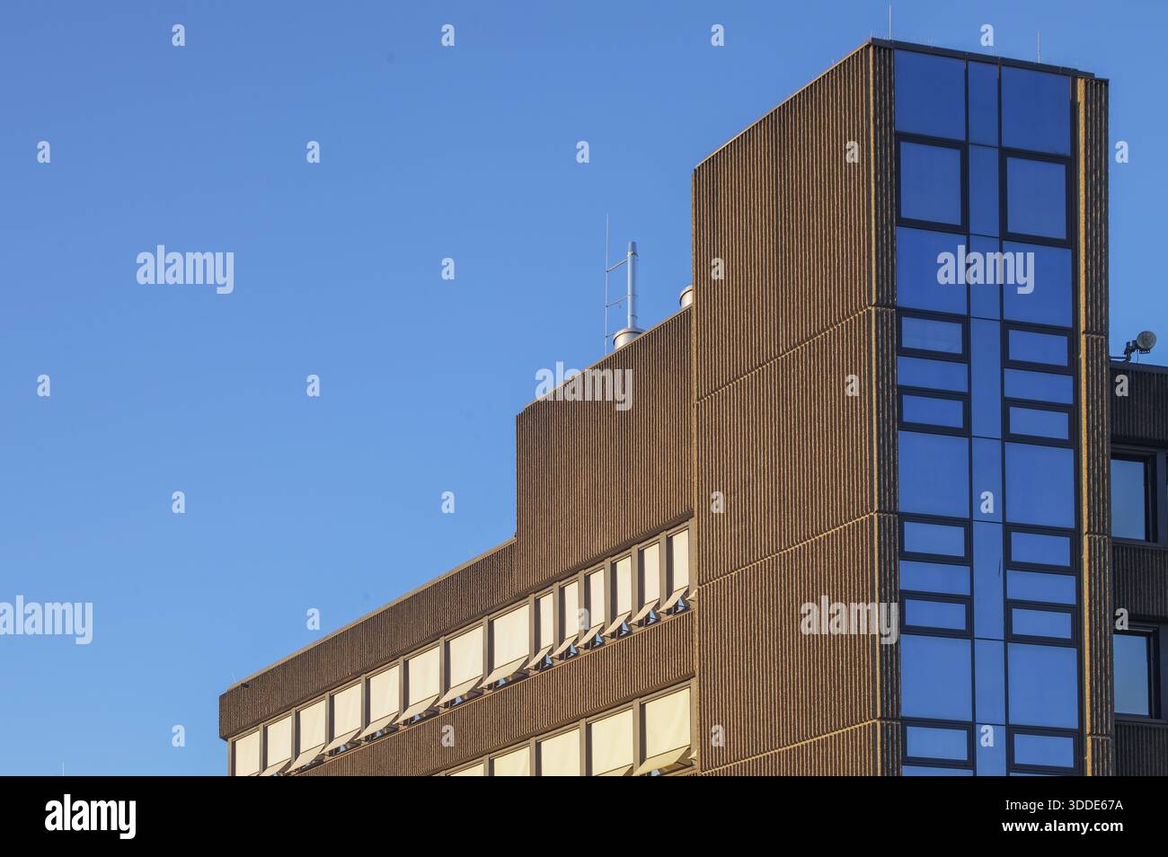 Borken, NRW, Germany, Modern brutalist building facade featuring concrete texture and reflective blue windows Stock Photo