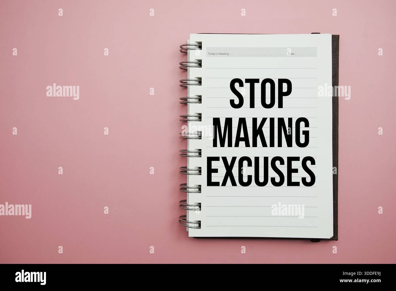 Stop Making Excuses text written on notepad with alarm clock Stock Photo