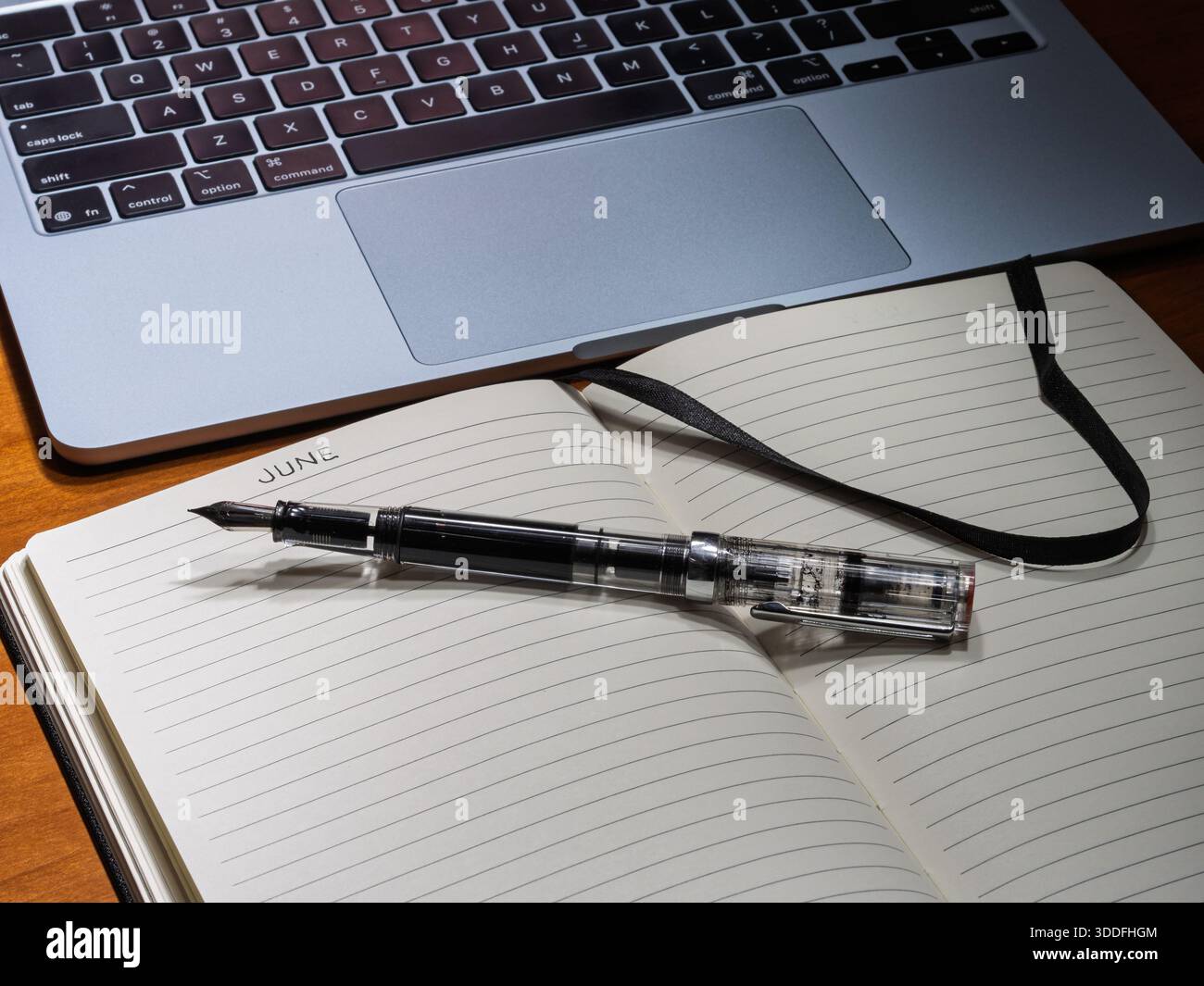 A creative June journaling session featuring analog writing tools alongside a digital workspace setup. Stock Photo