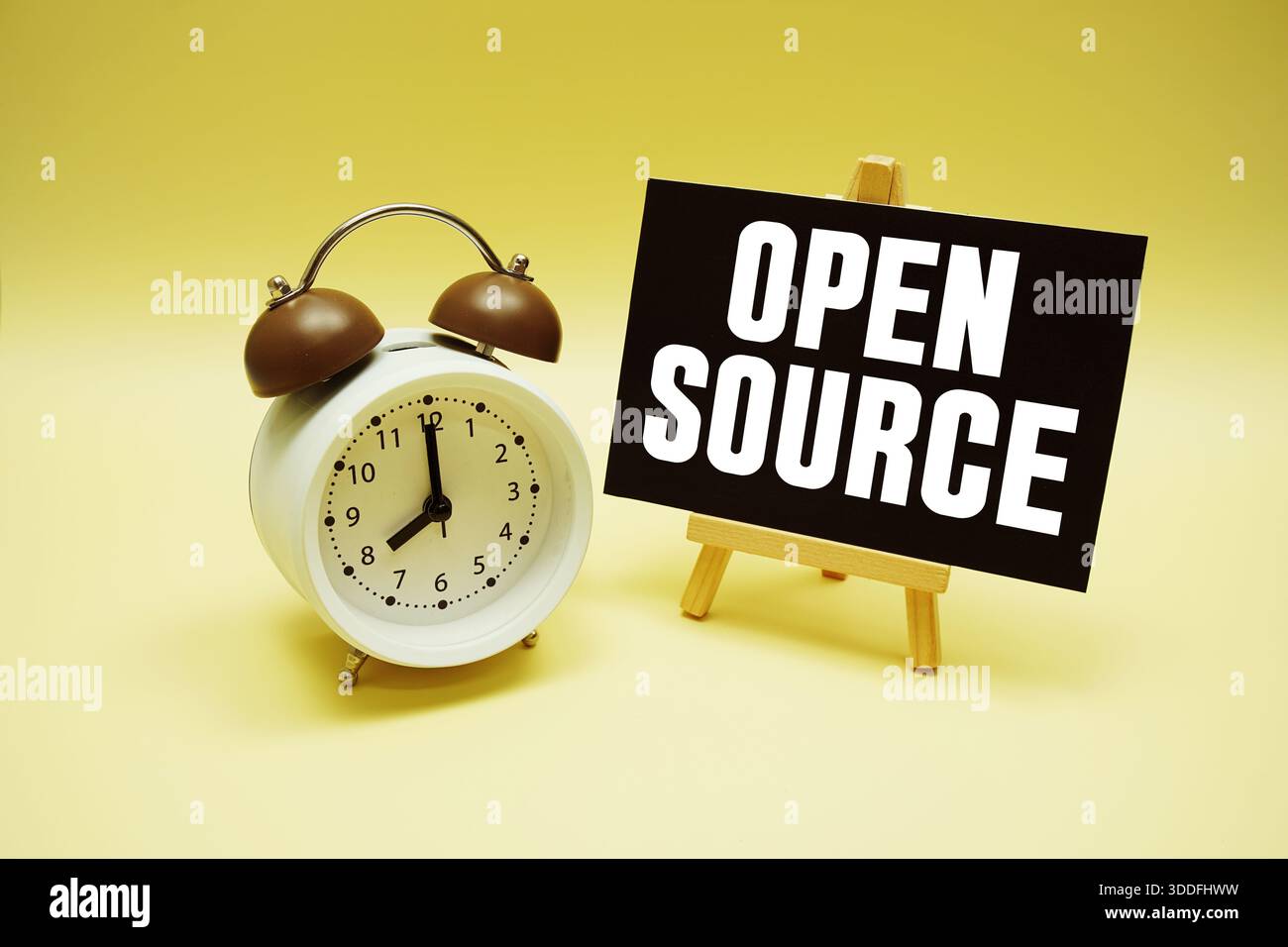 Open Source text message and alarm clock on yellow background Stock Photo