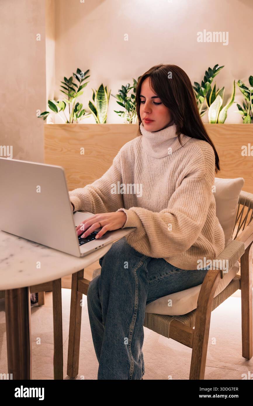 Woman working remotely on laptop at marble table Stock Photo