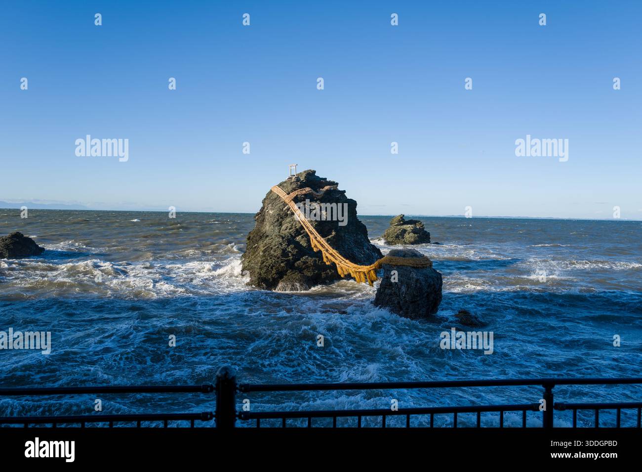 The Meoto Iwa rocks, joined by a thick shimenawa rope, rise from ...