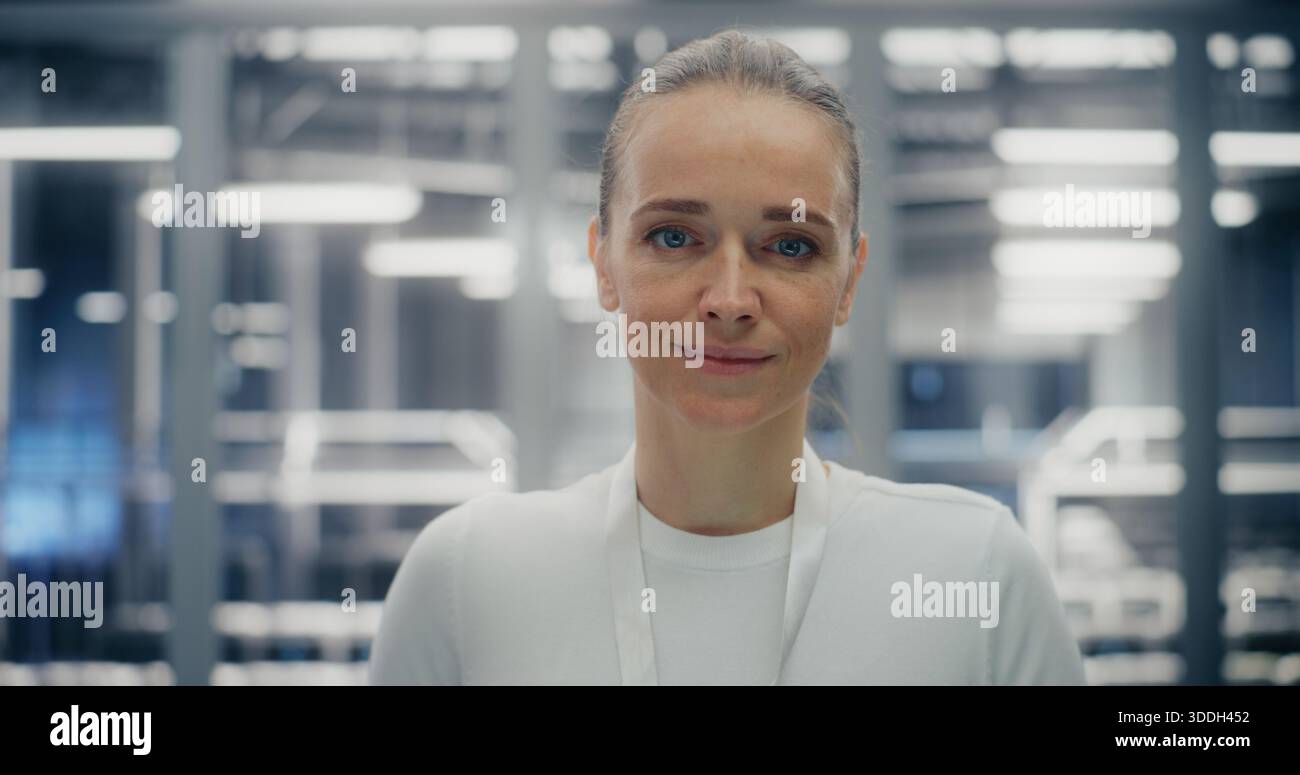 Close up of Confident Woman Working in Clean, Structured Environment of Secure Data Facility. Female Expression Friendly Yet Professional. Technical Competency and Reliable Infrastructure. Portrait. Stock Photo