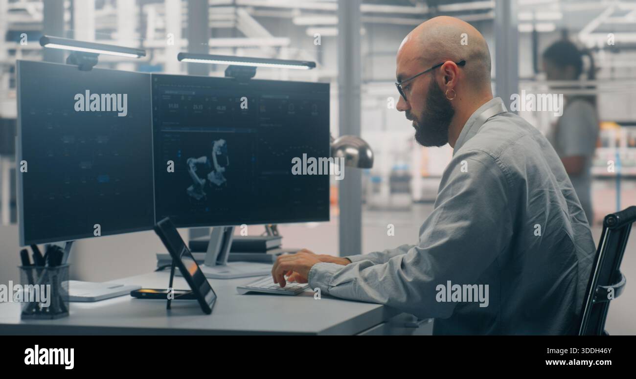 Two Monitor Man Programming Dual monitors displaying automation process hi-res stock photography ...