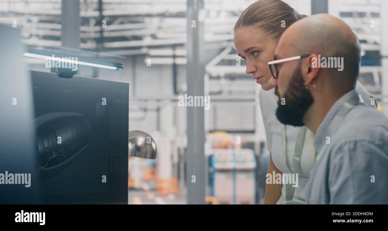 Specialists Discussing Manufacturing Specifications. Two Technical Specialists Deeply Engaged in Design Review, Examining Complex Technical Models on Computer Screen. Critical Problem Solving. Stock Photo