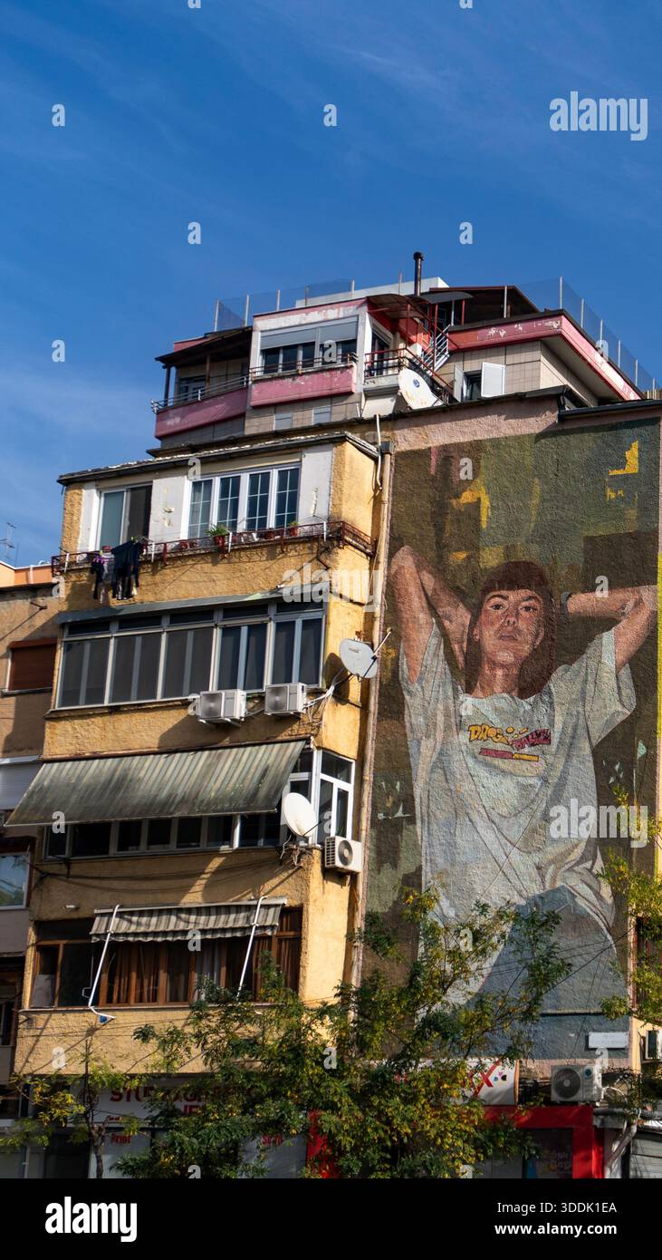 A 9:16 Portrait image of a large mural of a woman on the exterior of a residential building in Tirana, Albania - Stock Image