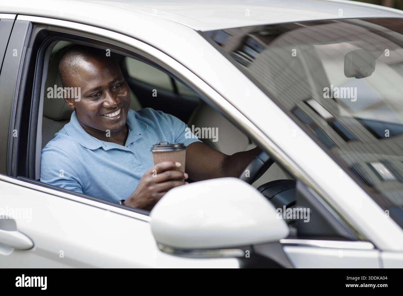 Relaxed black driver enjoying coffee break inside car Stock Photo