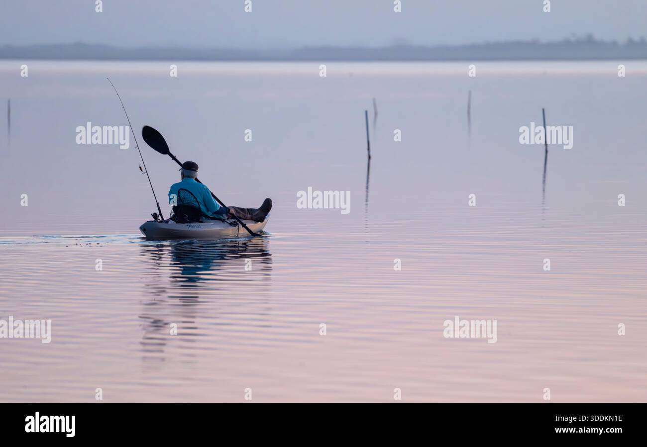 Fisherman on the boat, fishing early morning begore sunrise in the ocean Stock Photo