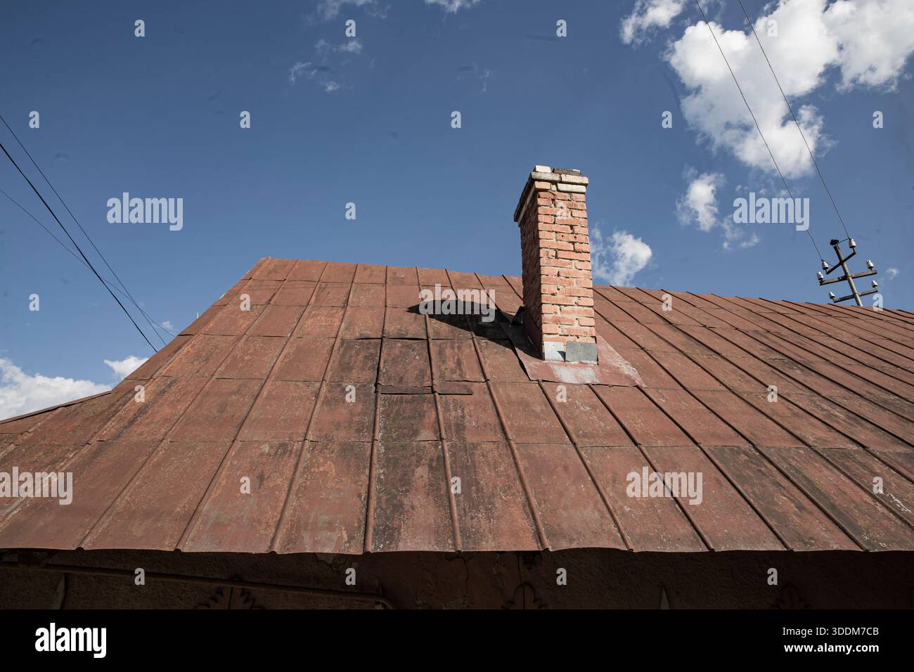 Old metal roof with brick chimney under blue sky and clouds Stock Photo ...